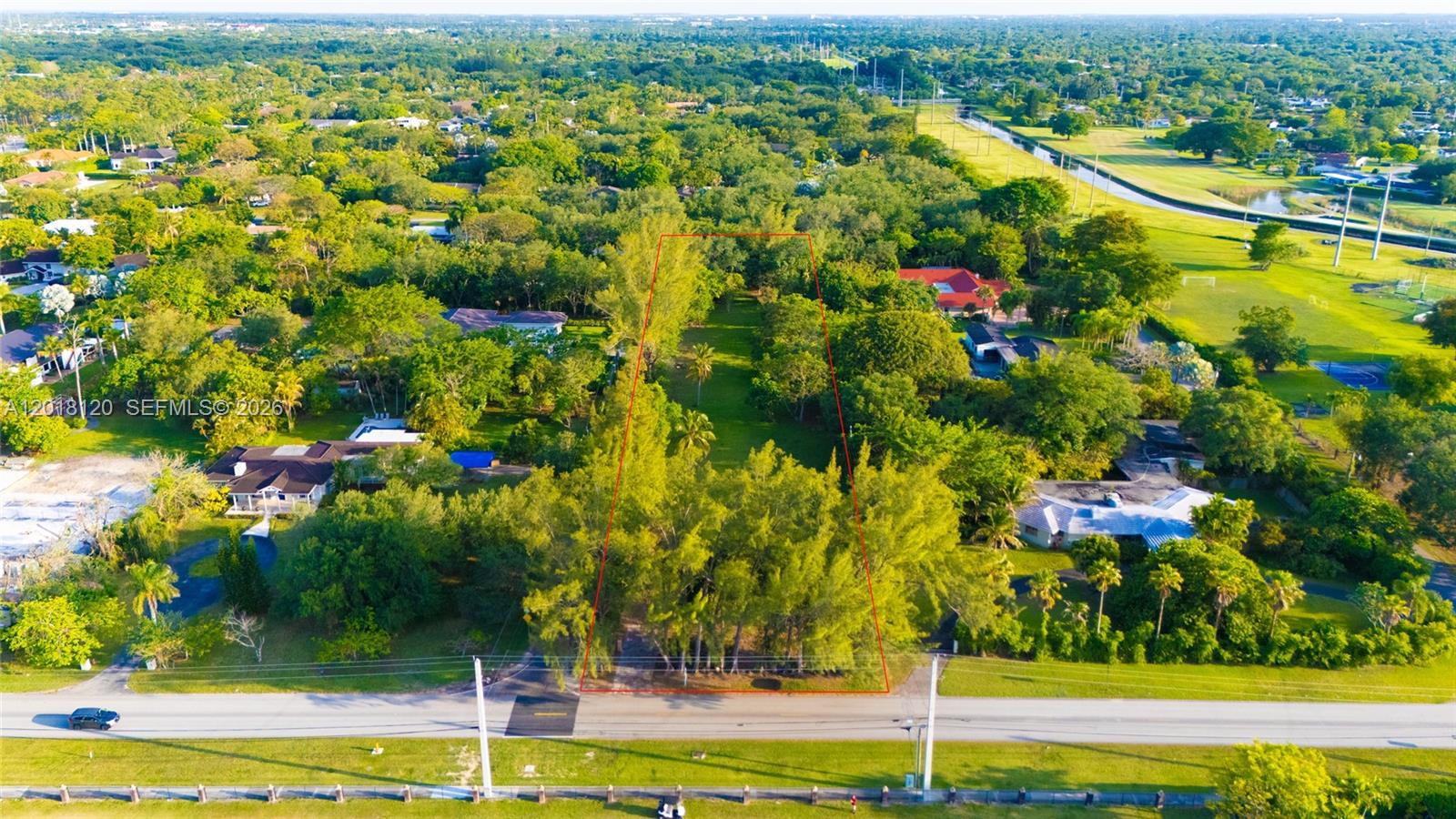 An aerial view shows a rectangular, tree-covered vacant lot outlined in red along a road — 9840 SW 104th St, Miami FL 33176, MIAMI, FL