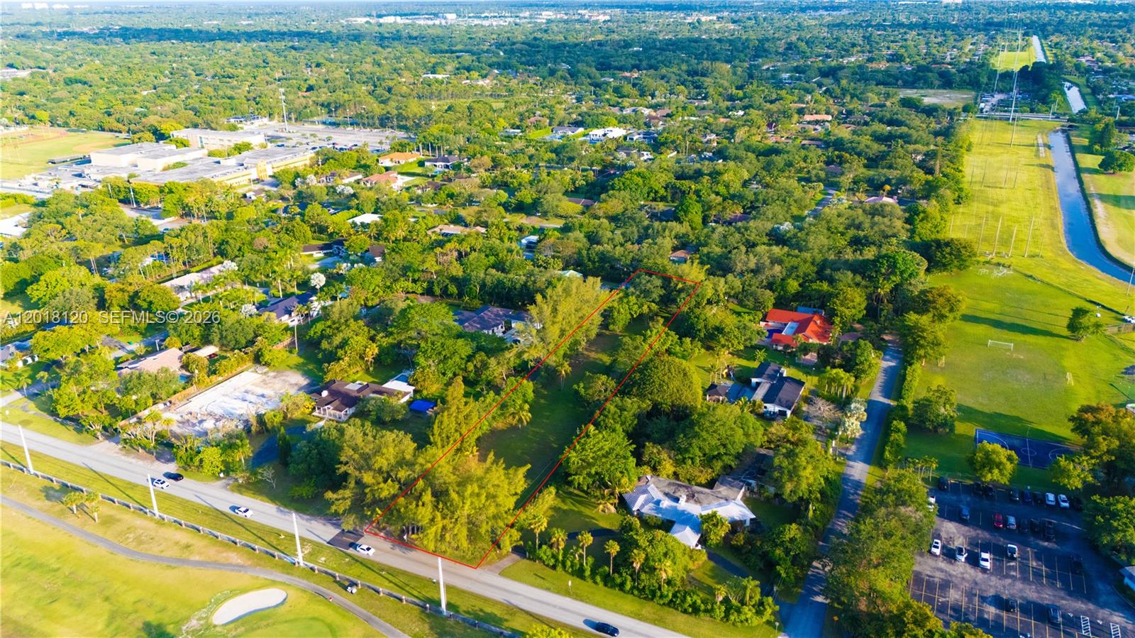 An aerial view shows a rectangular vacant lot outlined in red amidst a suburban neighborhood — 9840 SW 104th St, Miami FL 33176, MIAMI, FL