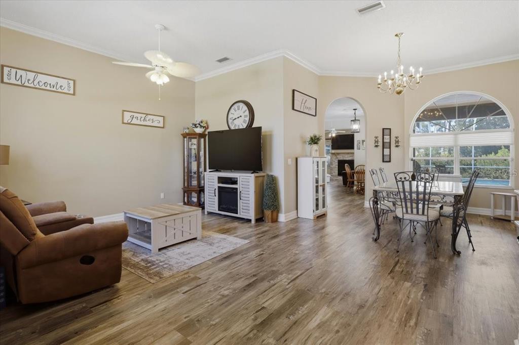 A living room features a brown loveseat, a wooden coffee table, and a large arched window — 56 WESTBURY LANE, PALM COAST, FL