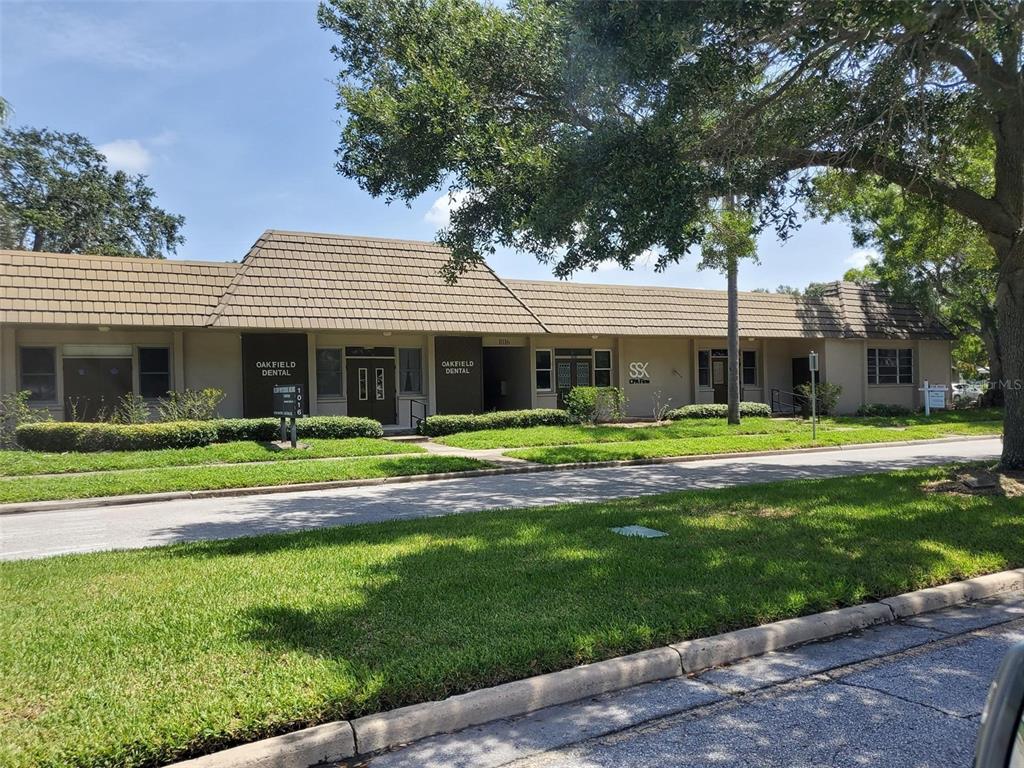 A single-story commercial building with tan siding, a brown tiled roof, and landscaped lawn — 1016 PONCE DE LEON BOULEVARD UNIT 2, CLEARWATER, FL