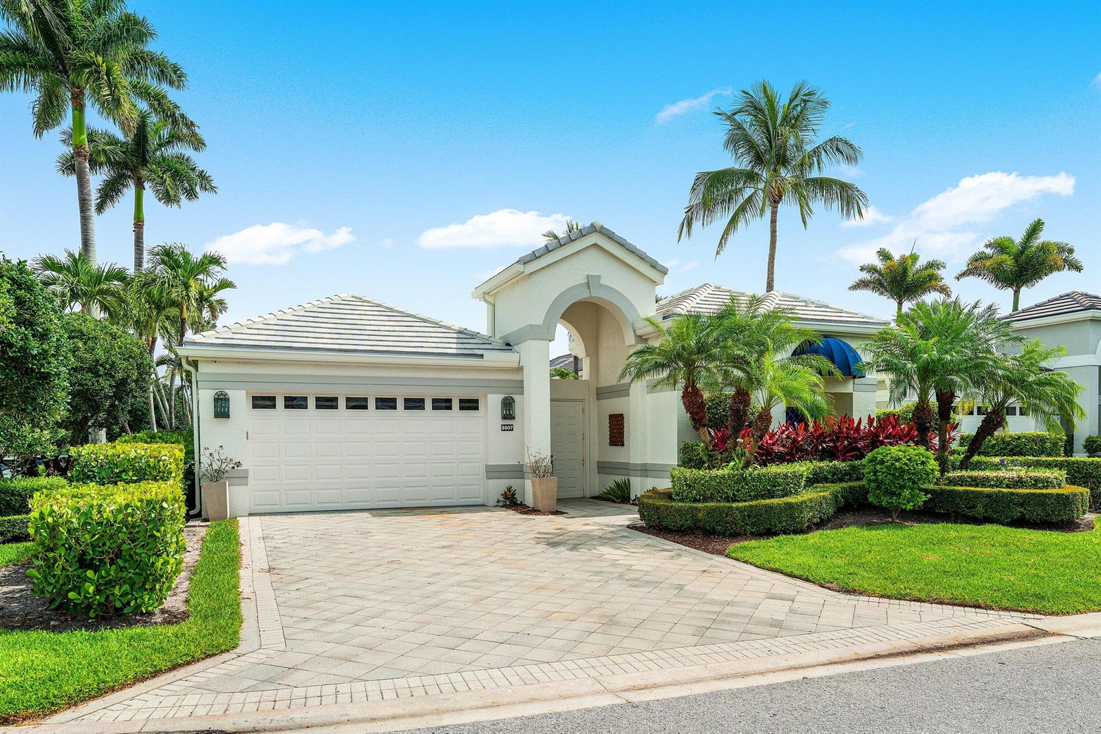 A single-story house with a paved driveway, a two-car garage, and palm trees — 3507 NW Clubside Circle, Boca Raton FL 33496, BOCA RATON, FL