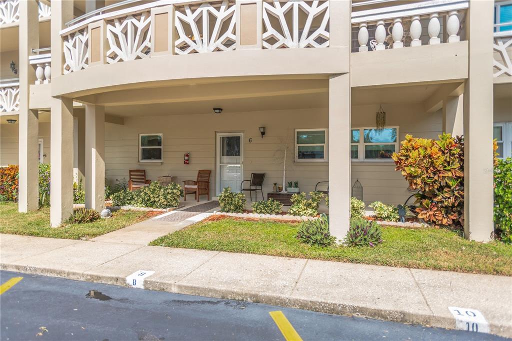 The exterior of a ground-level apartment unit features a covered patio, walkway, and parking spaces — 2350 HAITIAN DRIVE UNIT 6, CLEARWATER, FL