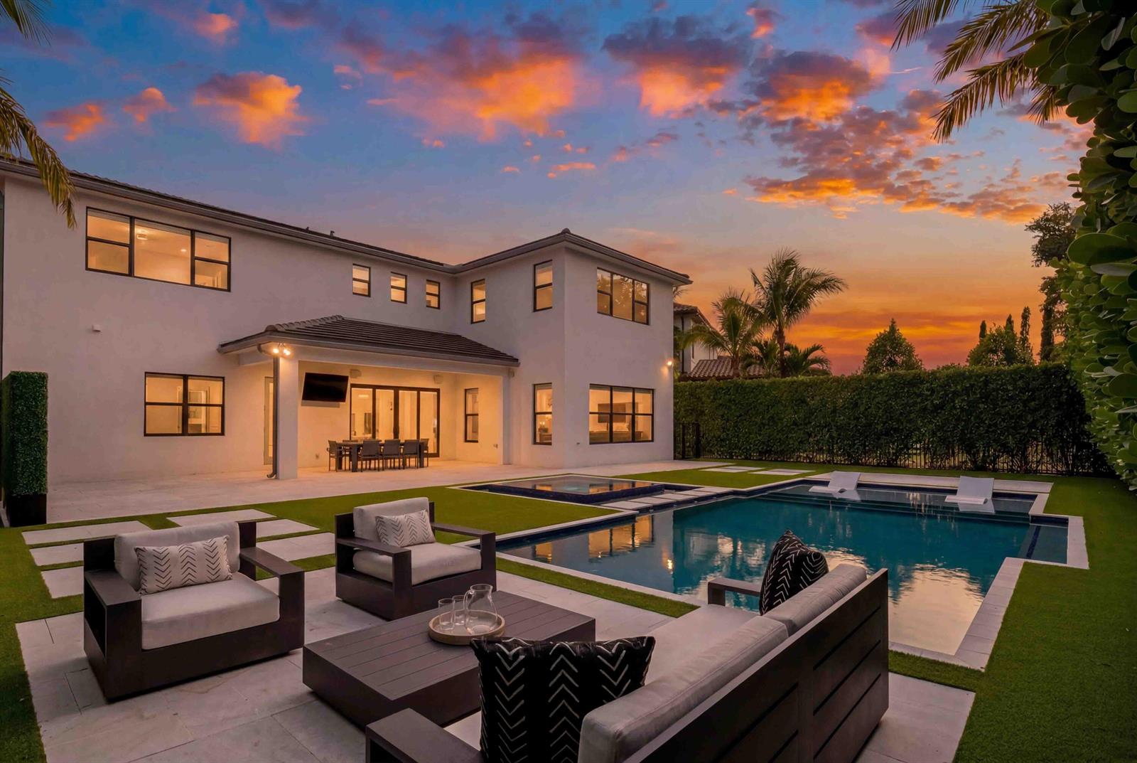 A modern two-story house with a pool, patio furniture, and a sunset sky — 17558 Cadena Drive, Boca Raton FL 33496, BOCA RATON, FL