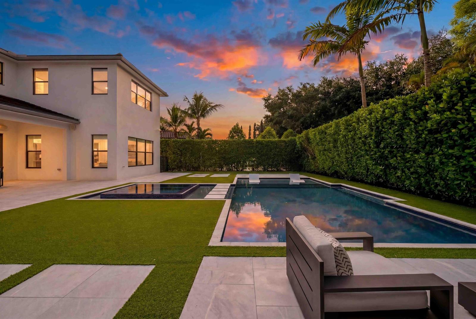 A modern house exterior features a swimming pool, spa, and artificial turf lawn at sunset — 17558 Cadena Drive, Boca Raton FL 33496, BOCA RATON, FL