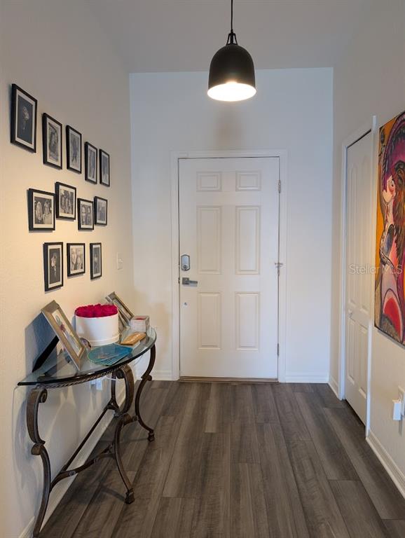 An entryway features a glass-topped console table, a gallery wall, and a white front door — 819 CHANNING STREET, WINTER HAVEN, FL
