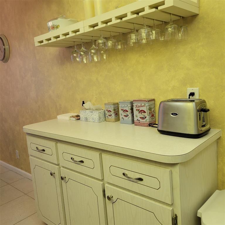 A kitchen cabinet with a toaster, canisters, and a hanging wine glass rack above — 351 Markham P # 351, Deerfield Beach FL 33442, DEERFIELD BEACH, FL