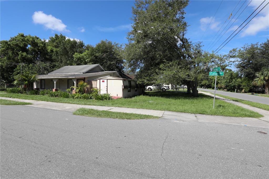 A single-story house with a shed sits on a corner lot near a street sign — 2747 EATON AVENUE, LAKELAND, FL