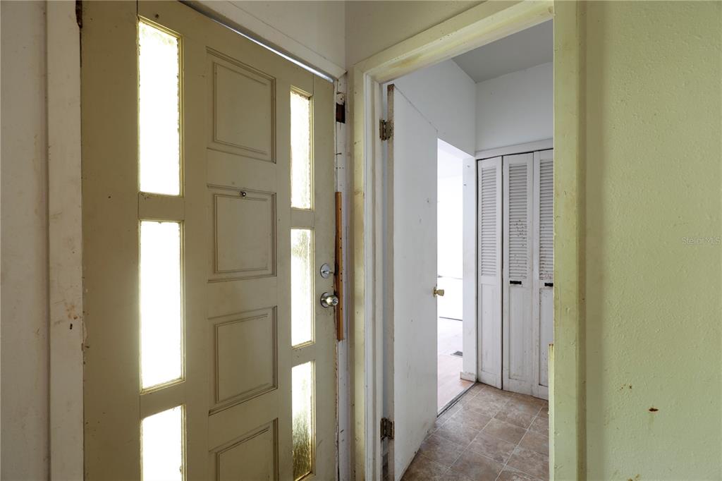 A view of an entryway with a paneled door and an adjacent doorway leading inside — 2747 EATON AVENUE, LAKELAND, FL
