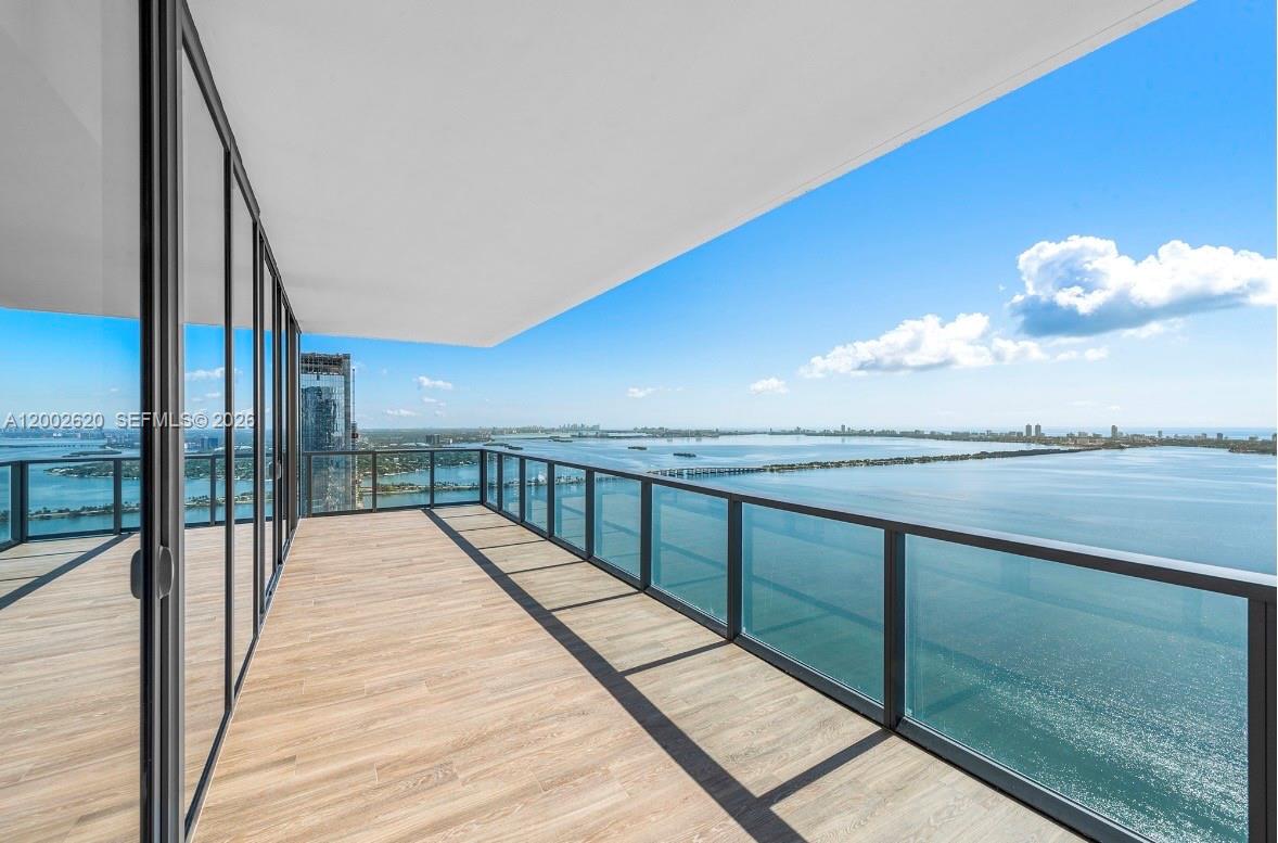 A high-rise balcony with wood-look tile flooring overlooks a large body of water — 788 NE 23rd St # 4802, Miami FL 33137, MIAMI, FL