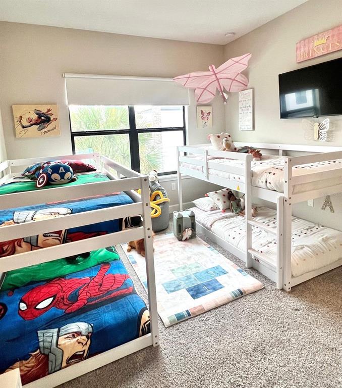 A bedroom features two white bunk beds, a hopscotch rug, and superhero-themed bedding — 136 VILLA DOMANI CIRCLE, DAVENPORT, FL