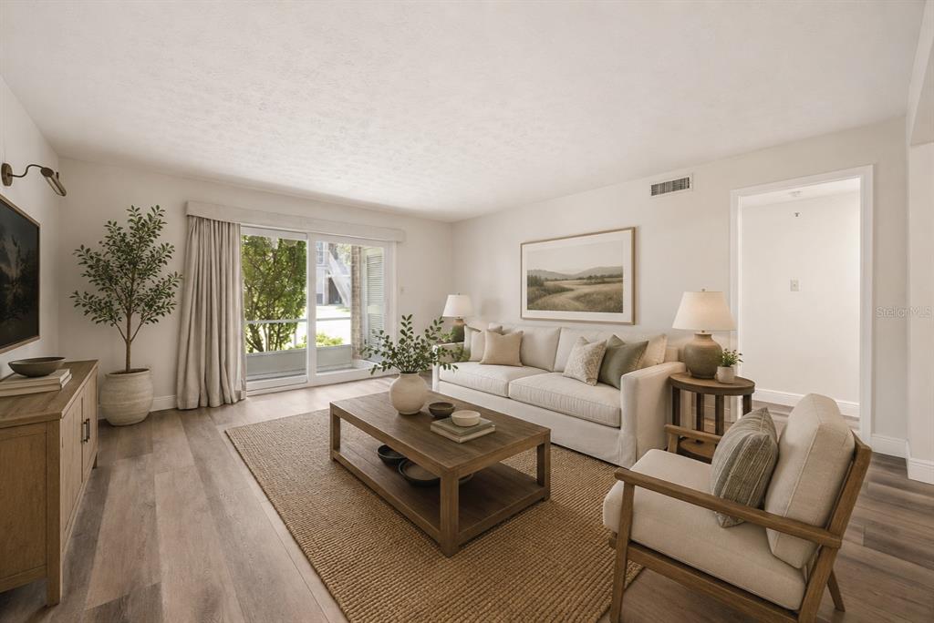 A living room features a sofa, armchair, coffee table, and sliding glass doors to outside — 4300 LAKE UNDERHILL ROAD UNIT 23B2, ORLANDO, FL