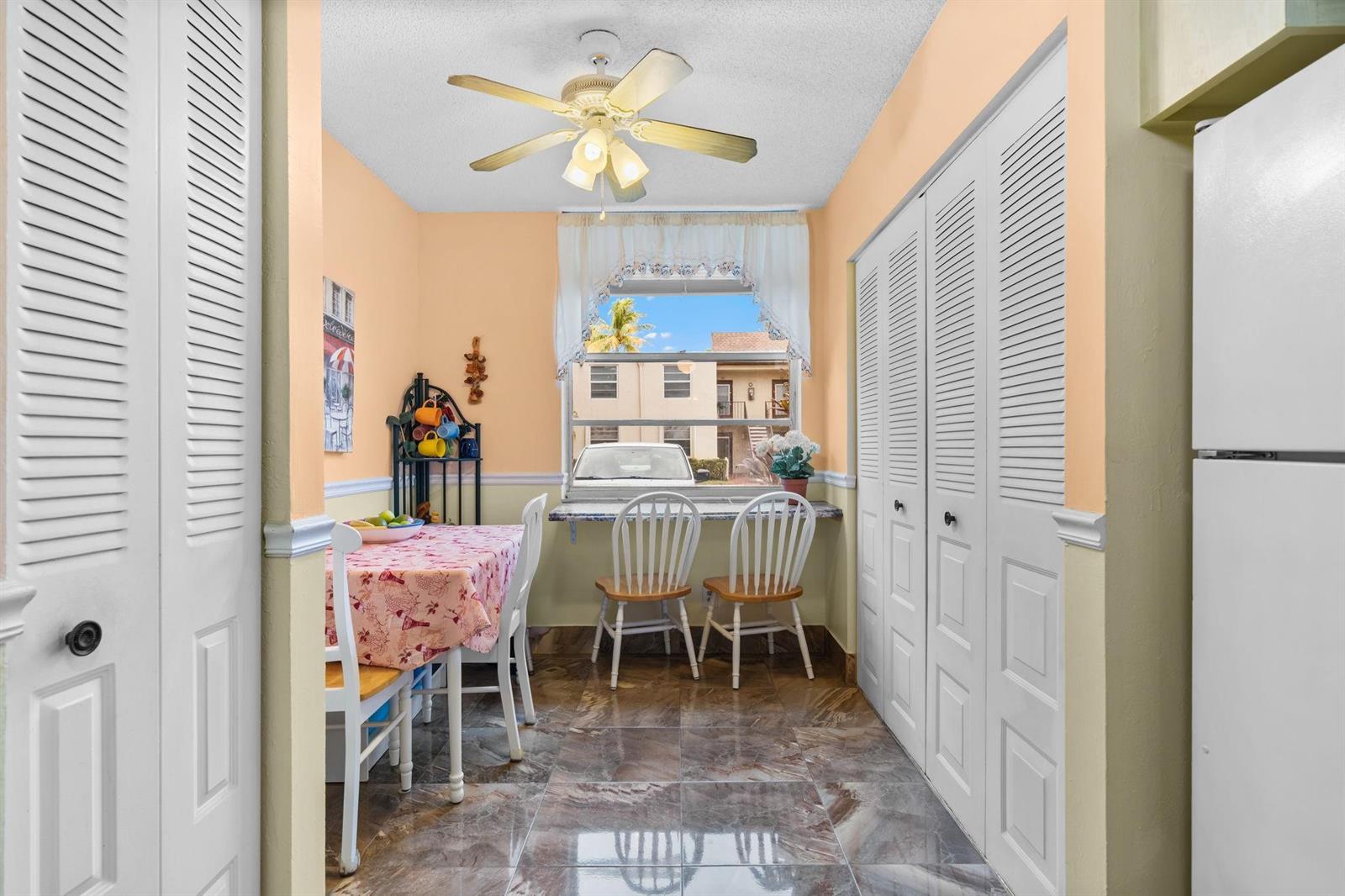 A small dining area features a table, two chairs, a window, and tiled flooring — 10 Willowbrook Lane # 108, Delray Beach FL 33446, DELRAY BEACH, FL