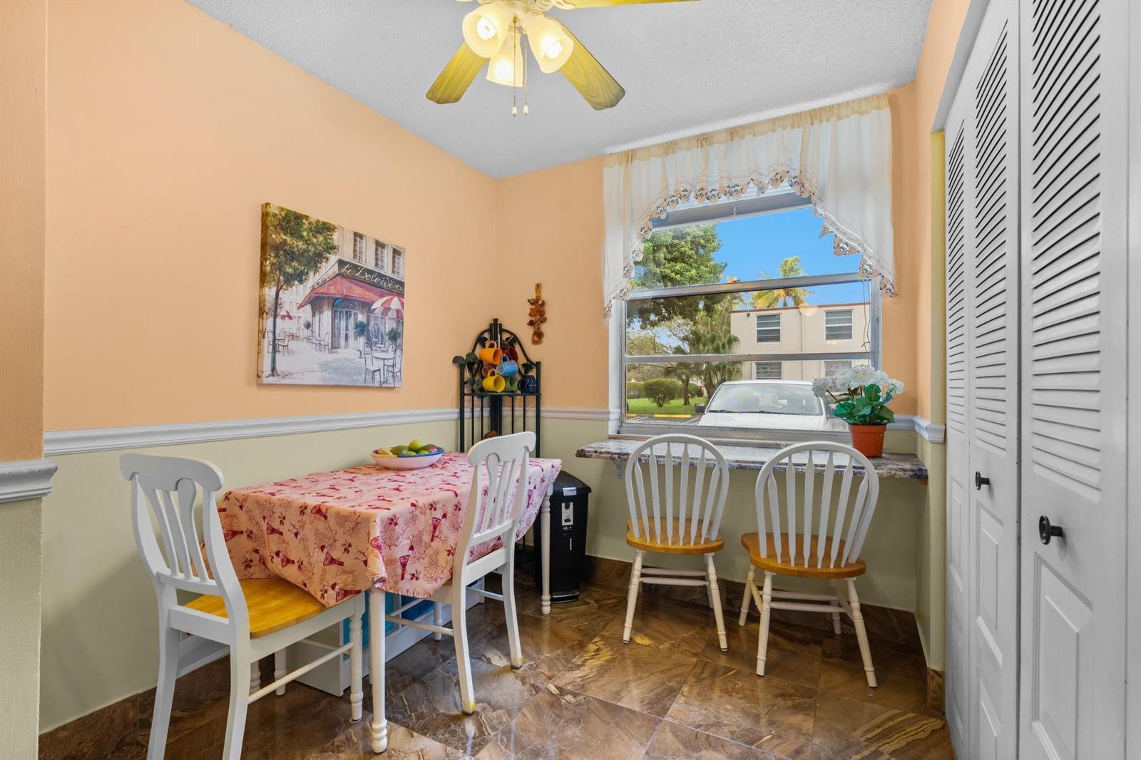 A dining area features a table with four chairs, a window, and tiled flooring — 10 Willowbrook Lane # 108, Delray Beach FL 33446, DELRAY BEACH, FL