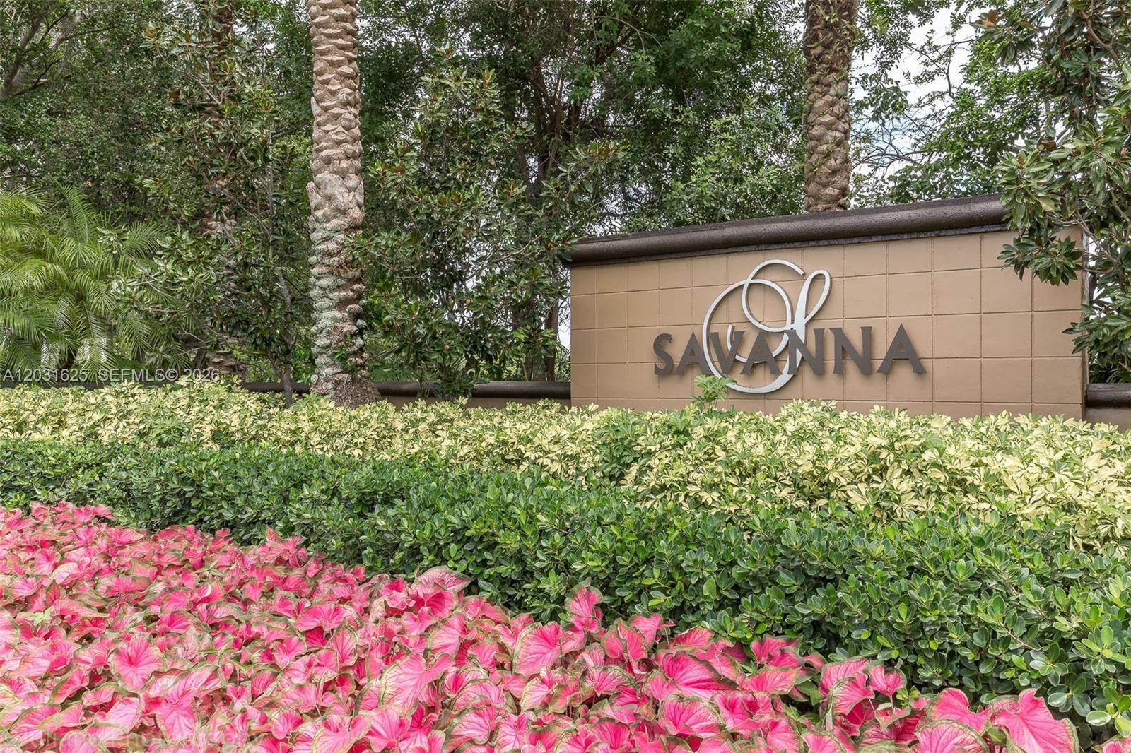 A sign for Savanna stands behind a garden of pink plants and green shrubs — 1032 Silktree Ln, Weston FL 33327, WESTON, FL