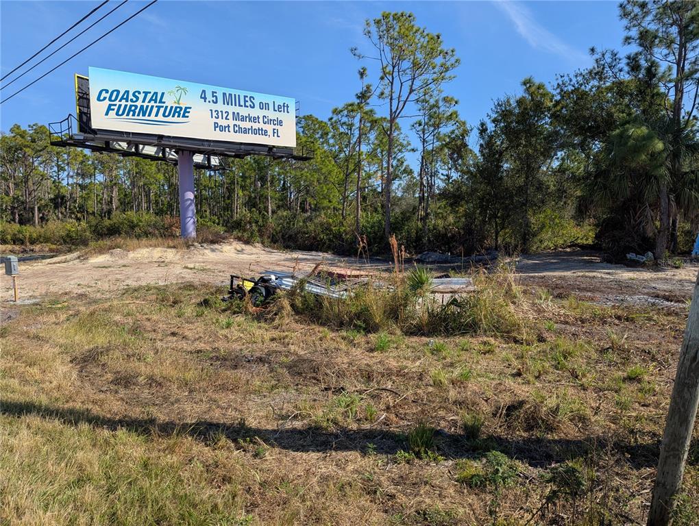 A large billboard for a furniture store stands on a grassy, undeveloped lot — 3512 EL JOBEAN ROAD, PORT CHARLOTTE, FL