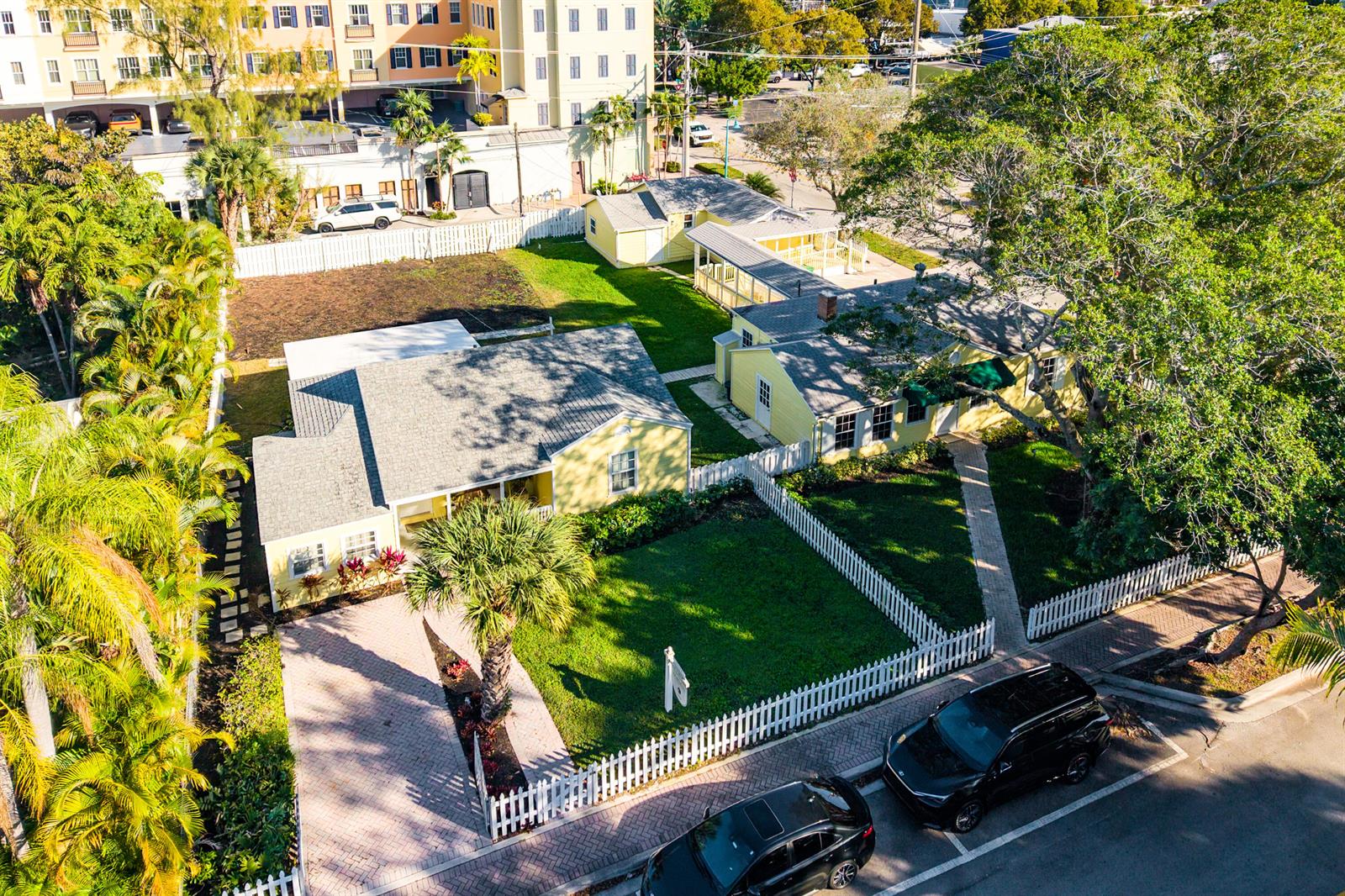 An aerial view shows two yellow houses with gray roofs and white picket fences — 201 NE 1st Avenue, Delray Beach FL 33444, DELRAY BEACH, FL