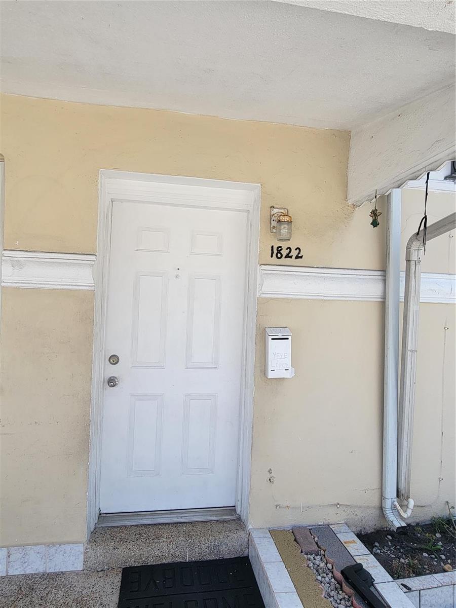 A white front door with a house number and mailbox on a beige exterior wall — 1822 Johnson Street, Hollywood FL 33020, HOLLYWOOD, FL