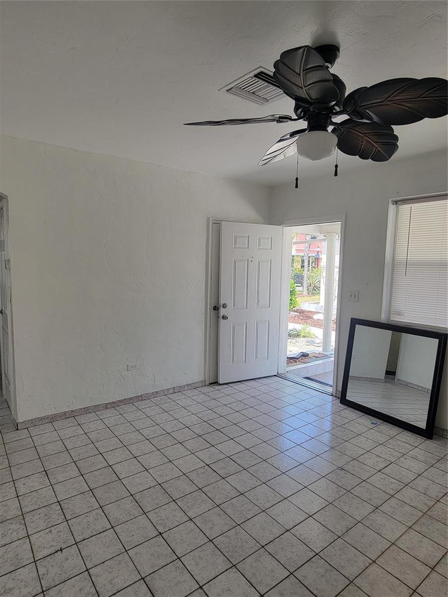 A room with white tiled floors, a ceiling fan, and an open door to outside — 1822 Johnson Street, Hollywood FL 33020, HOLLYWOOD, FL