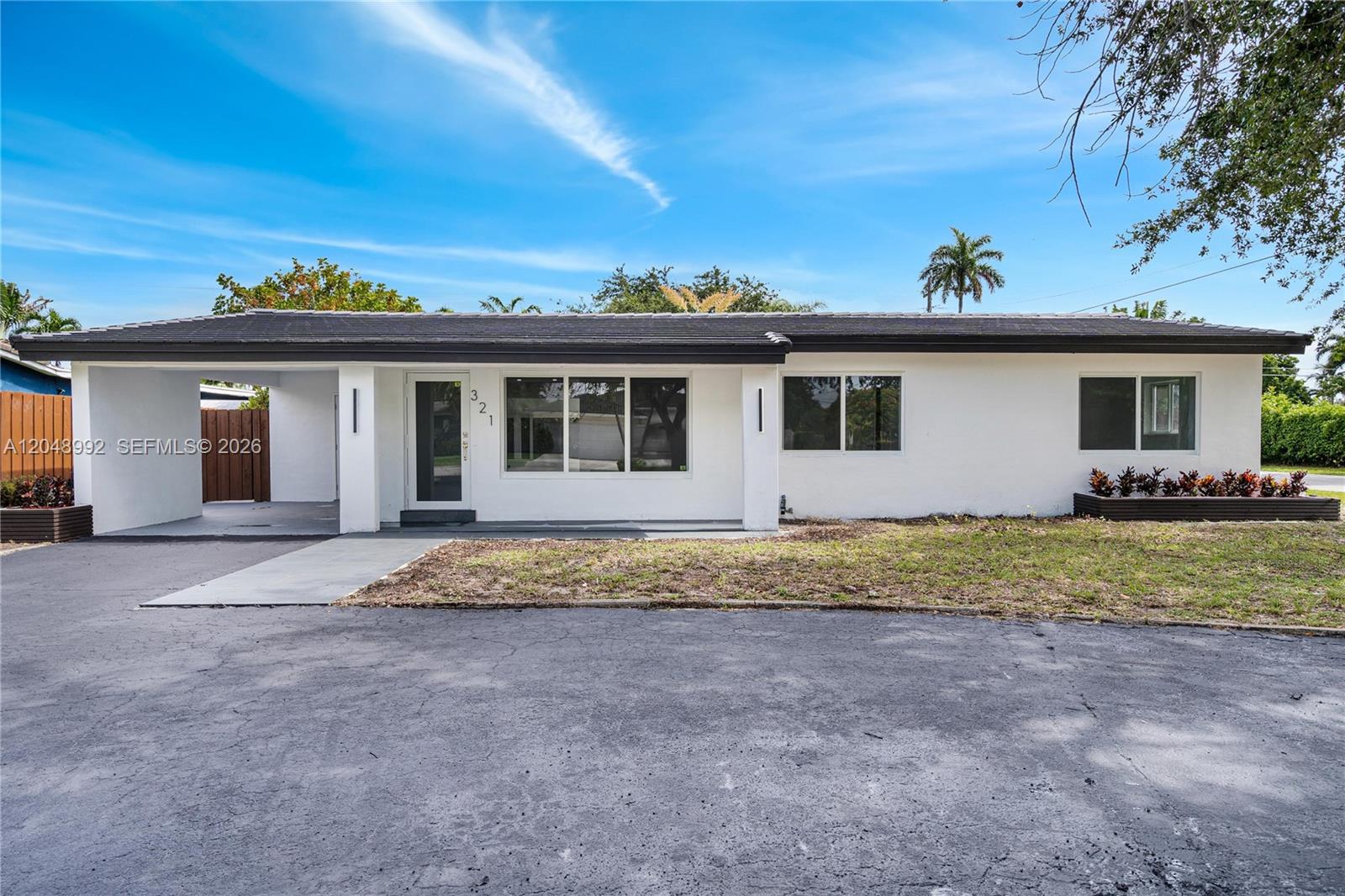 A white, single-story house with a flat roof, carport, and a paved driveway — 321 NW 36th St, Oakland Park FL 33309, OAKLAND PARK, FL