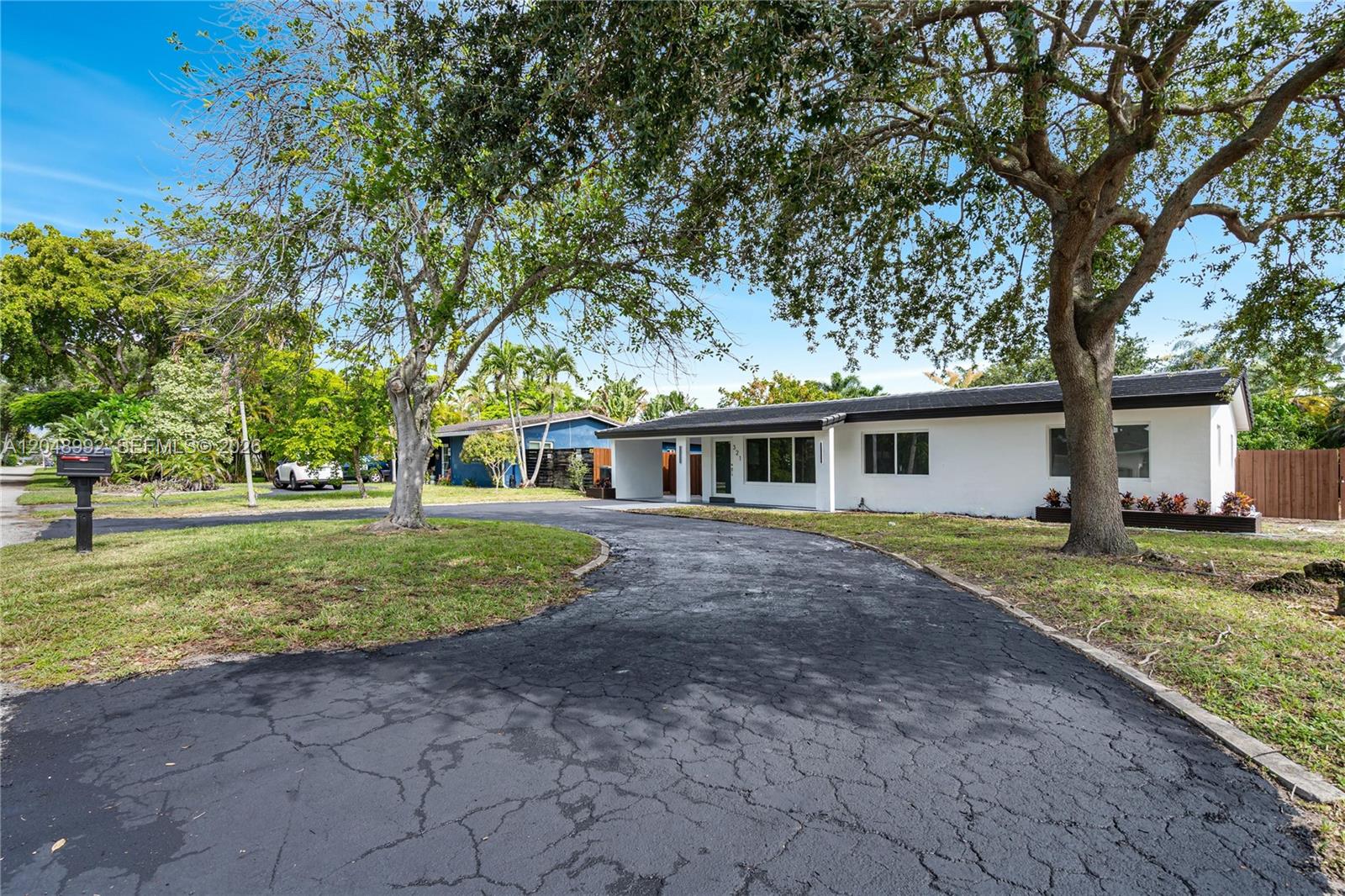A white single-story house features a curved asphalt driveway and large shade trees — 321 NW 36th St, Oakland Park FL 33309, OAKLAND PARK, FL