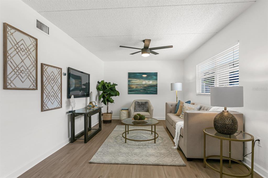 A living room features a beige sofa, a glass coffee table, and a ceiling fan — 807 S HOWARD AVENUE UNIT 209, TAMPA, FL