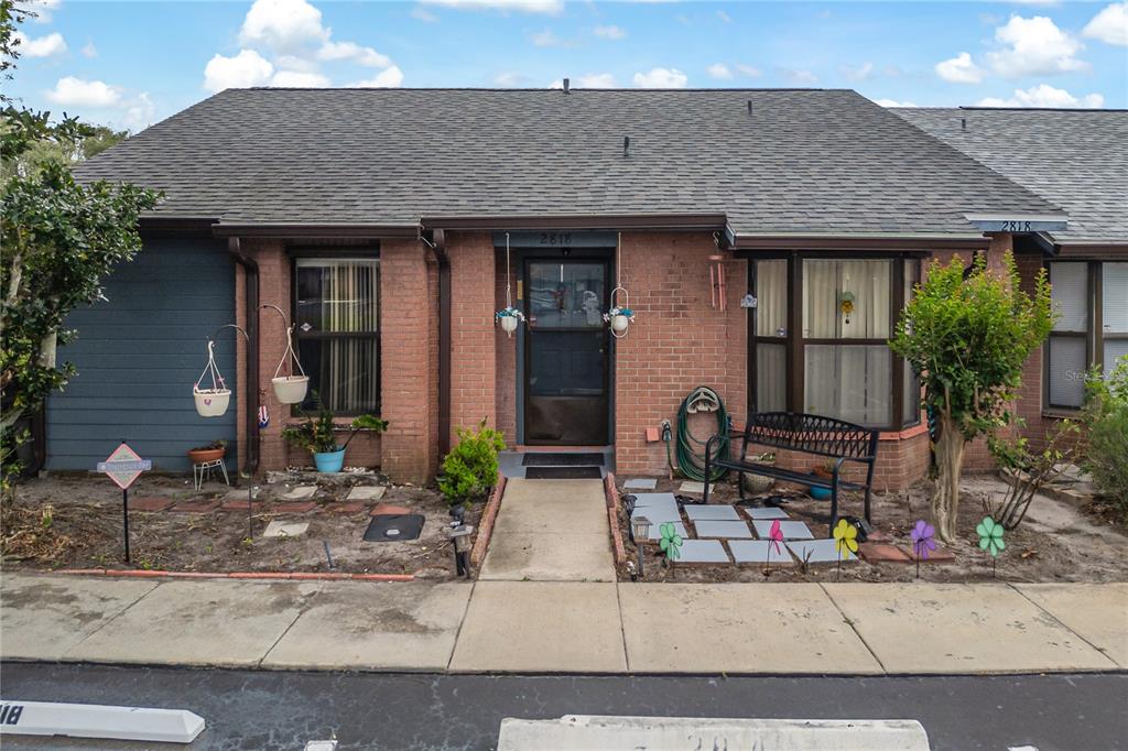 A single-story brick townhouse with a gray shingled roof and a front walkway — 2818 SHANNON OAK COURT, ST CLOUD, FL
