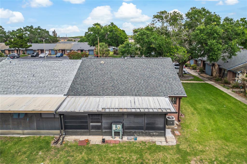 An aerial view shows the back of a townhouse with a screened-in patio and roof — 2818 SHANNON OAK COURT, ST CLOUD, FL
