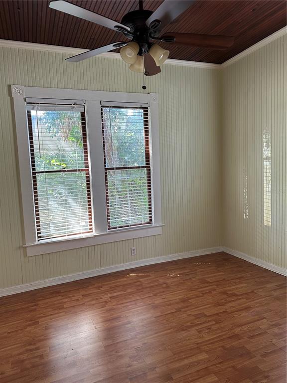 A room with light-colored vertical wall paneling, wood-look flooring, and a dark wood-paneled ceiling — 109 HIBISCUS STREET UNIT 1, TARPON SPRINGS, FL