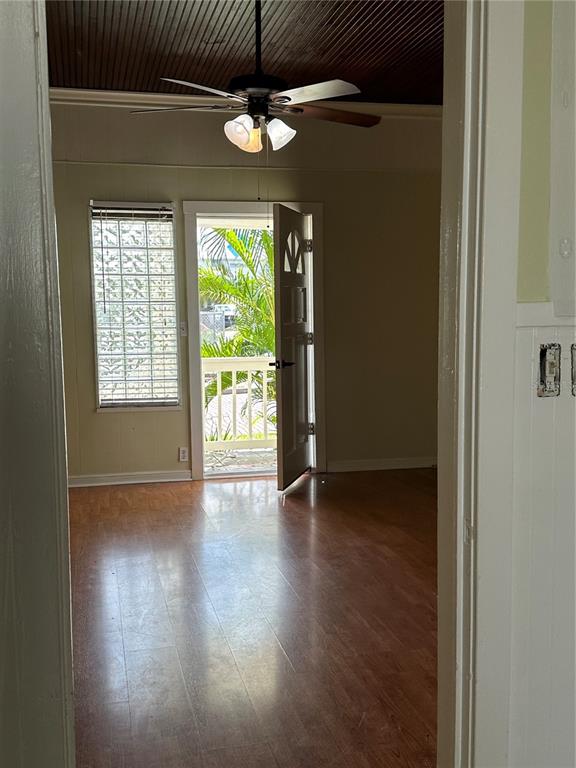 A room with wood-look flooring, a ceiling fan, and a door opening to a balcony — 109 HIBISCUS STREET UNIT 1, TARPON SPRINGS, FL