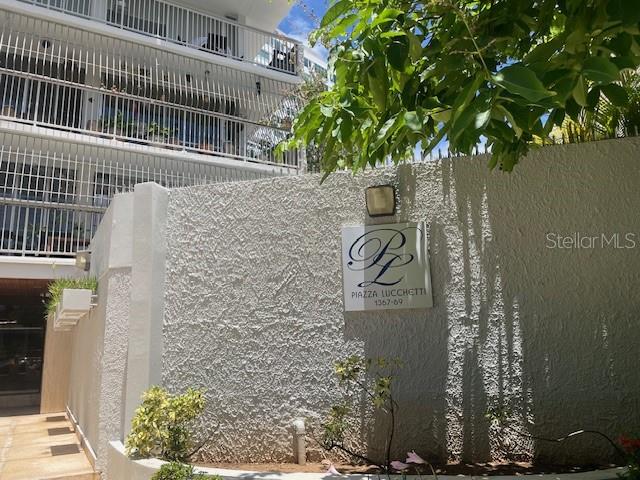 A textured wall features a sign for Piazza Lucchetti beneath a multi-story residential building — 1367 COND. PIAZZA LUCHETTI UNIT 7-B, SAN JUAN, PR
