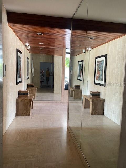A hallway features wood-paneled ceilings, travertine walls and floors, and a large wall mirror — 1367 COND. PIAZZA LUCHETTI UNIT 7-B, SAN JUAN, PR