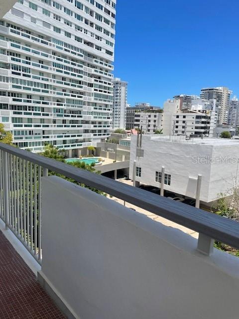 A view from a balcony overlooking a swimming pool and neighboring high-rise buildings — 1367 COND. PIAZZA LUCHETTI UNIT 7-B, SAN JUAN, PR