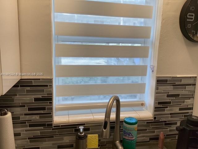 A kitchen window features horizontal zebra blinds above a sink with a tiled backsplash — 3133 S Ocean Dr # 118, Hallandale Beach FL 33009, HALLANDALE BEACH, FL