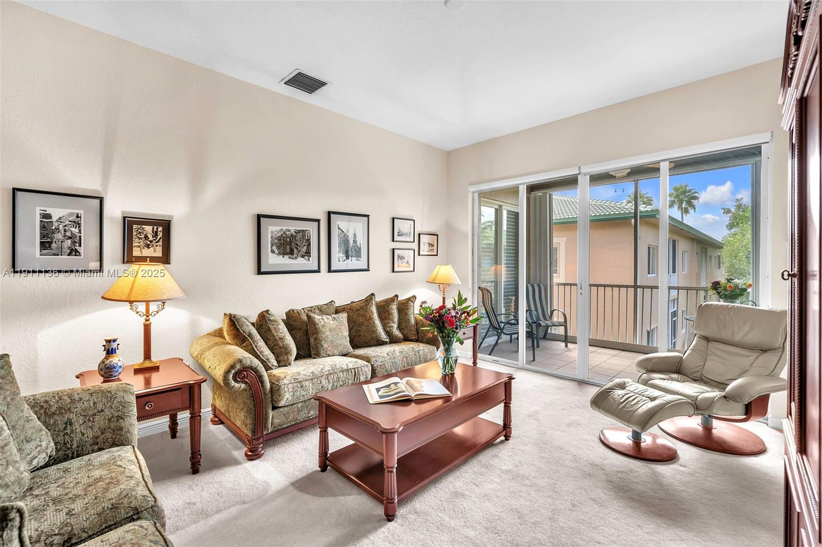 A living room features a patterned sofa, a coffee table, and a leather recliner — 7921 E Exeter Blvd E # 202, Tamarac FL 33321, TAMARAC, FL