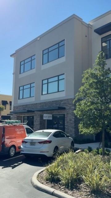 A three-story commercial building with stone veneer accents and a parking lot in front — 13564 VILLAGE PARK DRIVE UNIT O-365, ORLANDO, FL