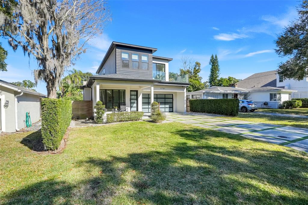 A modern two-story house with a flat roof, glass balcony, and a paved driveway — 1751 GOODRICH AVENUE, WINTER PARK, FL
