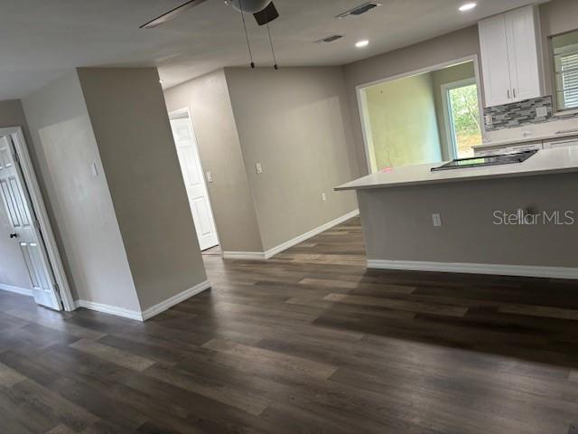 An open-concept kitchen and living area feature wood-look flooring, white cabinets, and a kitchen island — 17 S JEFFERSON STREET, BEVERLY HILLS, FL
