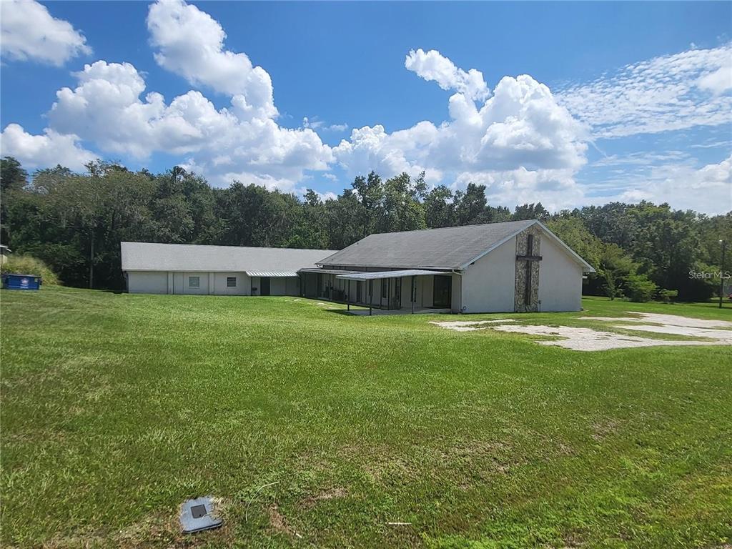 A low-slung church building with a stone cross on the exterior wall sits on grass — 4626 S PIPKIN ROAD, LAKELAND, FL