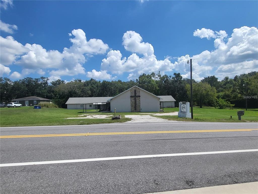 A single-story church building with a stone cross facade sits behind a paved road — 4626 S PIPKIN ROAD, LAKELAND, FL