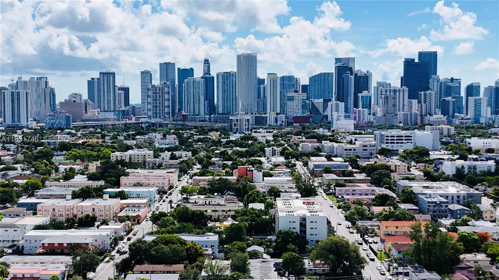 An aerial view of a dense urban neighborhood with a large skyline of skyscrapers behind — 1236 SW 4th St, Miami FL 33135, MIAMI, FL