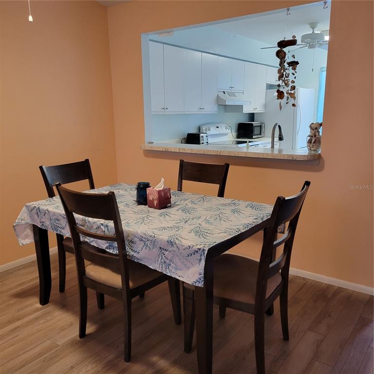 A dining area with a table and chairs sits in front of a kitchen pass-through window — 2713 60TH AVENUE DRIVE W, BRADENTON, FL