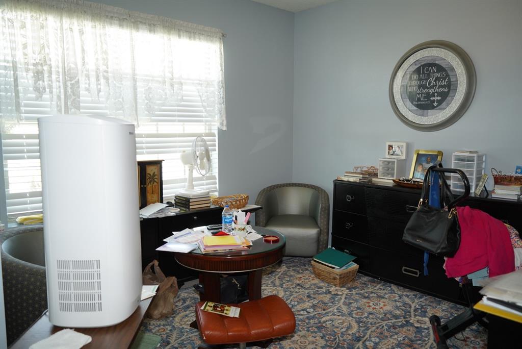 A room with a round table, chairs, a dresser, and a large air purifier — 128 CITRUS ISLE STREET S, DAVENPORT, FL