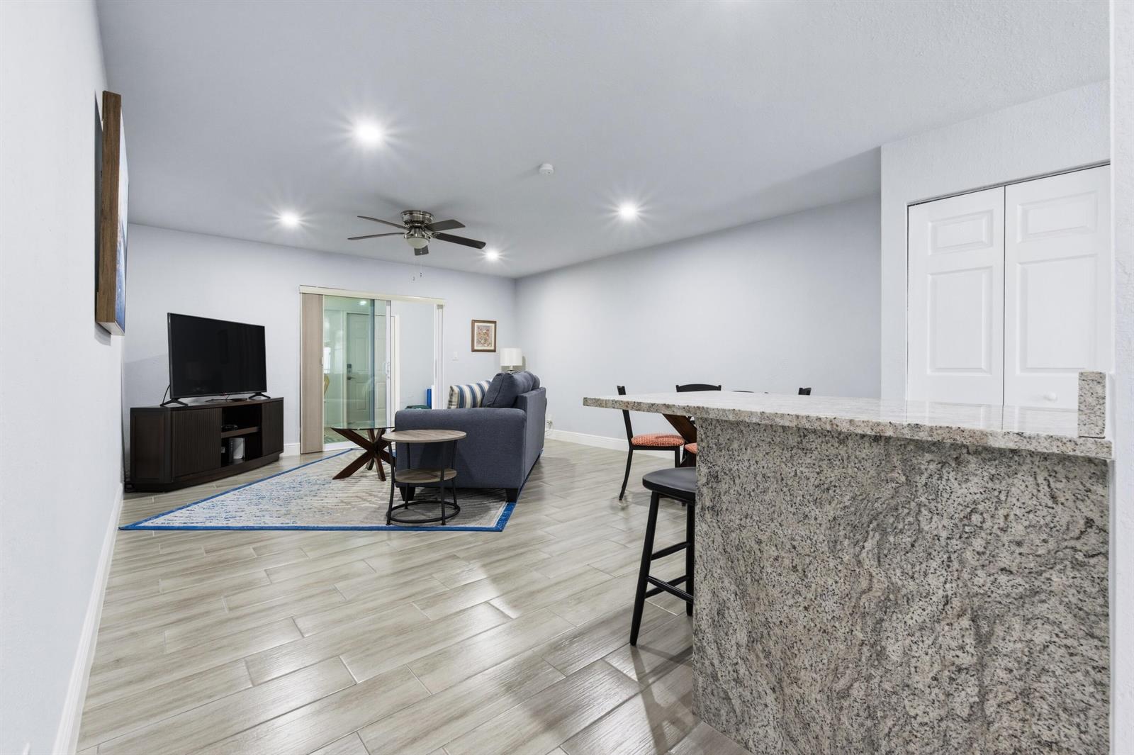 A living room and dining area with tile flooring, a granite breakfast bar, and furniture — 586 Laconia Circle, Lake Worth FL 33467, LAKE WORTH, FL