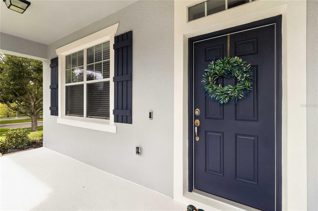 A front porch with a dark blue door, a wreath, and matching shutters on a window — 2071 RAFTON ROAD, APOPKA, FL