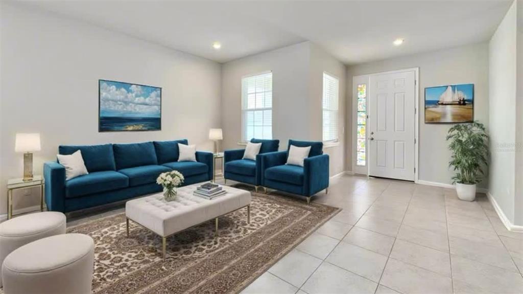 A living room features a blue sofa, two matching armchairs, a tufted ottoman, and tile flooring — 3954 GREAT SMOKEY WAY, APOPKA, FL