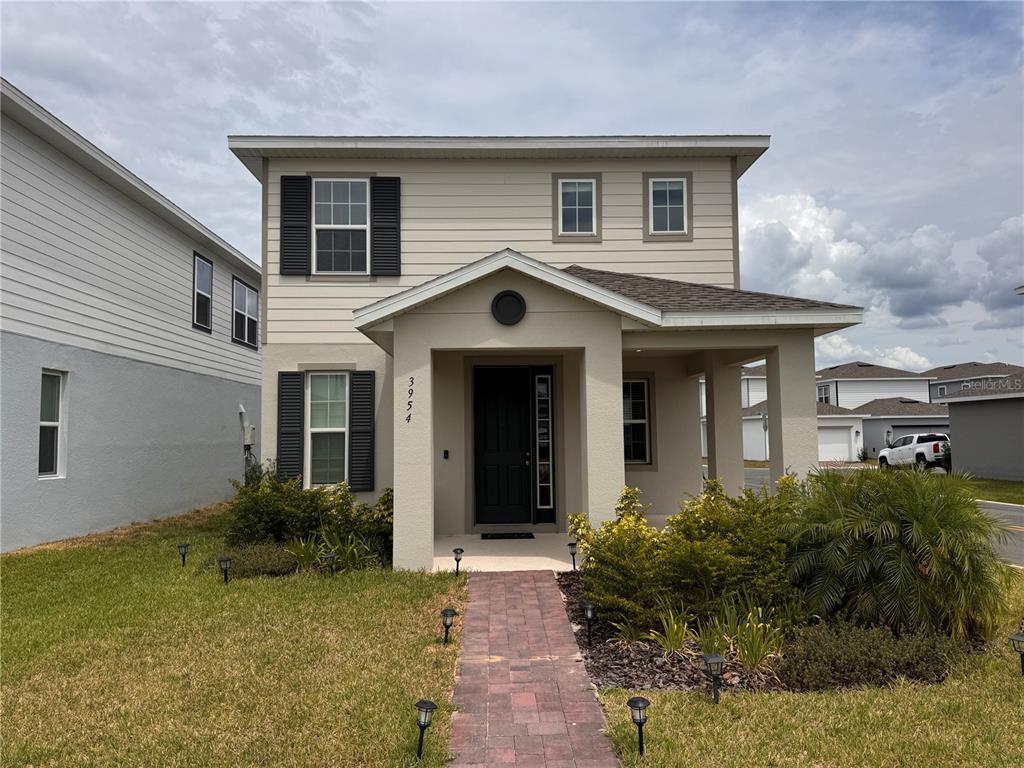 A two-story house with beige siding, a covered front porch, and a brick walkway — 3954 GREAT SMOKEY WAY, APOPKA, FL