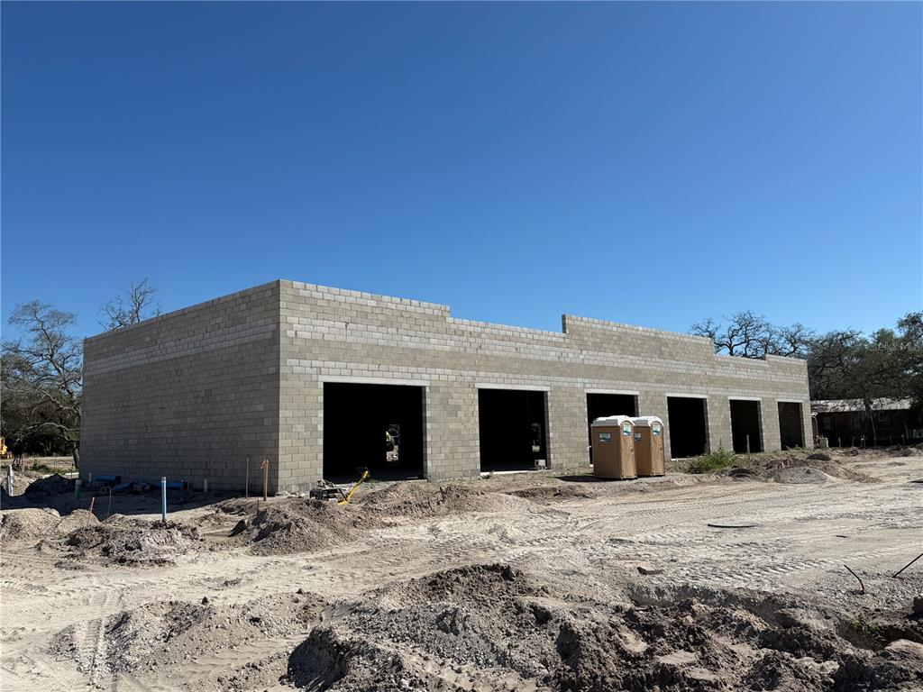 An exterior view of a concrete block commercial building under construction with five open bays — 6204 INTERBAY BOULEVARD, TAMPA, FL