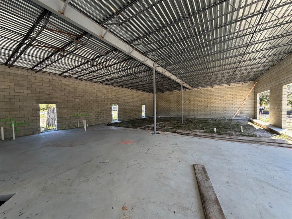 An unfinished commercial interior features concrete block walls, a metal deck ceiling, and exposed dirt — 6204 INTERBAY BOULEVARD, TAMPA, FL