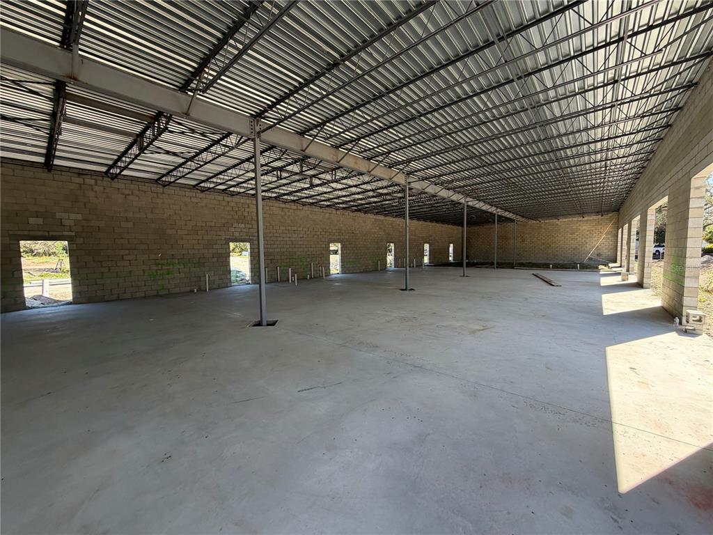An unfinished commercial building interior features concrete block walls, a metal roof, and concrete flooring — 6204 INTERBAY BOULEVARD, TAMPA, FL