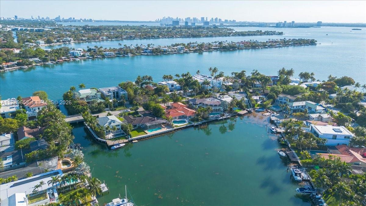 An aerial view shows waterfront homes with swimming pools and docks along a canal — 1249 Biscaya Dr, Surfside FL 33154, SURFSIDE, FL
